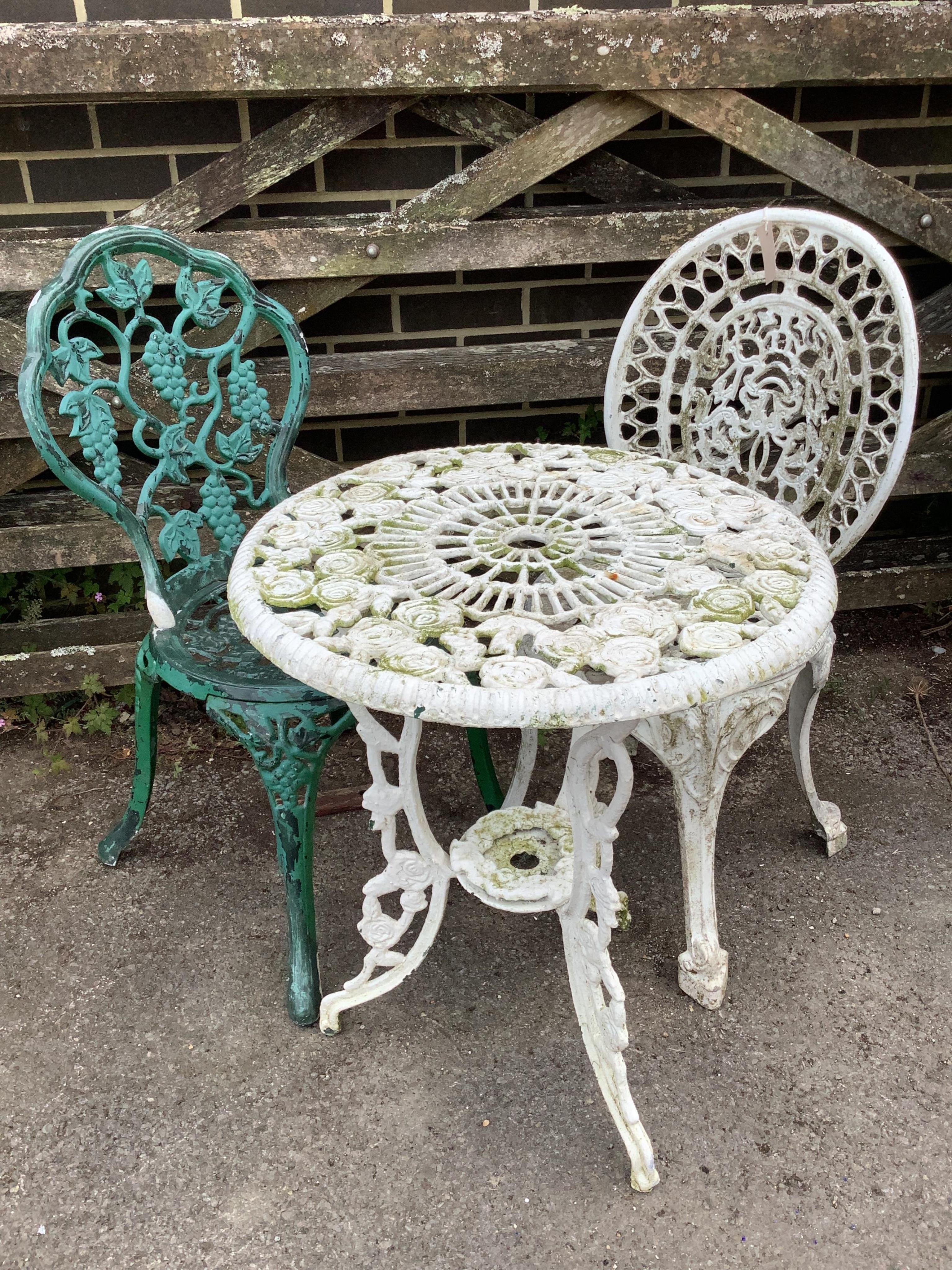 A Victorian style painted aluminium circular garden table, diameter 56cm, height 65cm, and two chairs. Condition - poor to fair